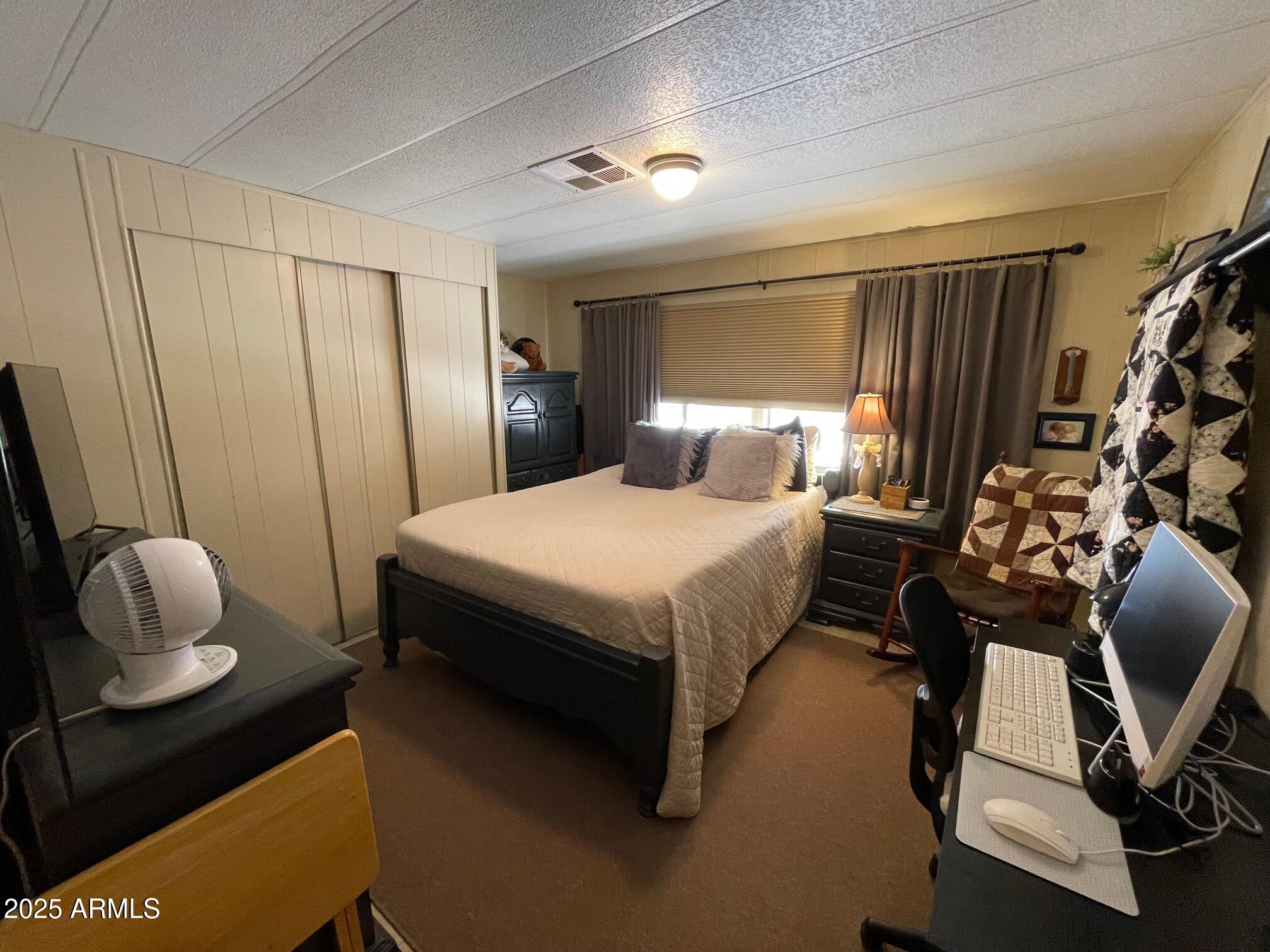 980 East Broadway Avenue, Unit 15 Apache Junction, AZ 85119 - Photo 16 of 24 a bedroom with a bed and a window