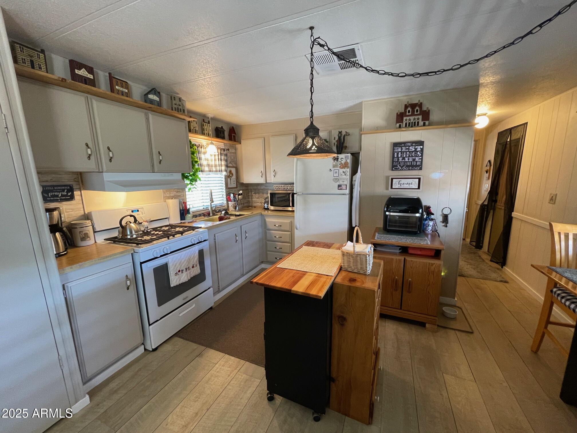 980 East Broadway Avenue, Unit 15 Apache Junction, AZ 85119 - Photo 9 of 24 a kitchen with granite countertop a sink appliances and cabinets
