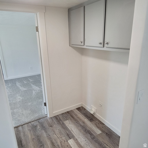 1735 South 1380 West Logan, UT 84321 - Photo 17 of 46 Dedicated laundry area featuring wood-finish flooring, white walls, and built-in upper cabinetry with silver-tone hardware