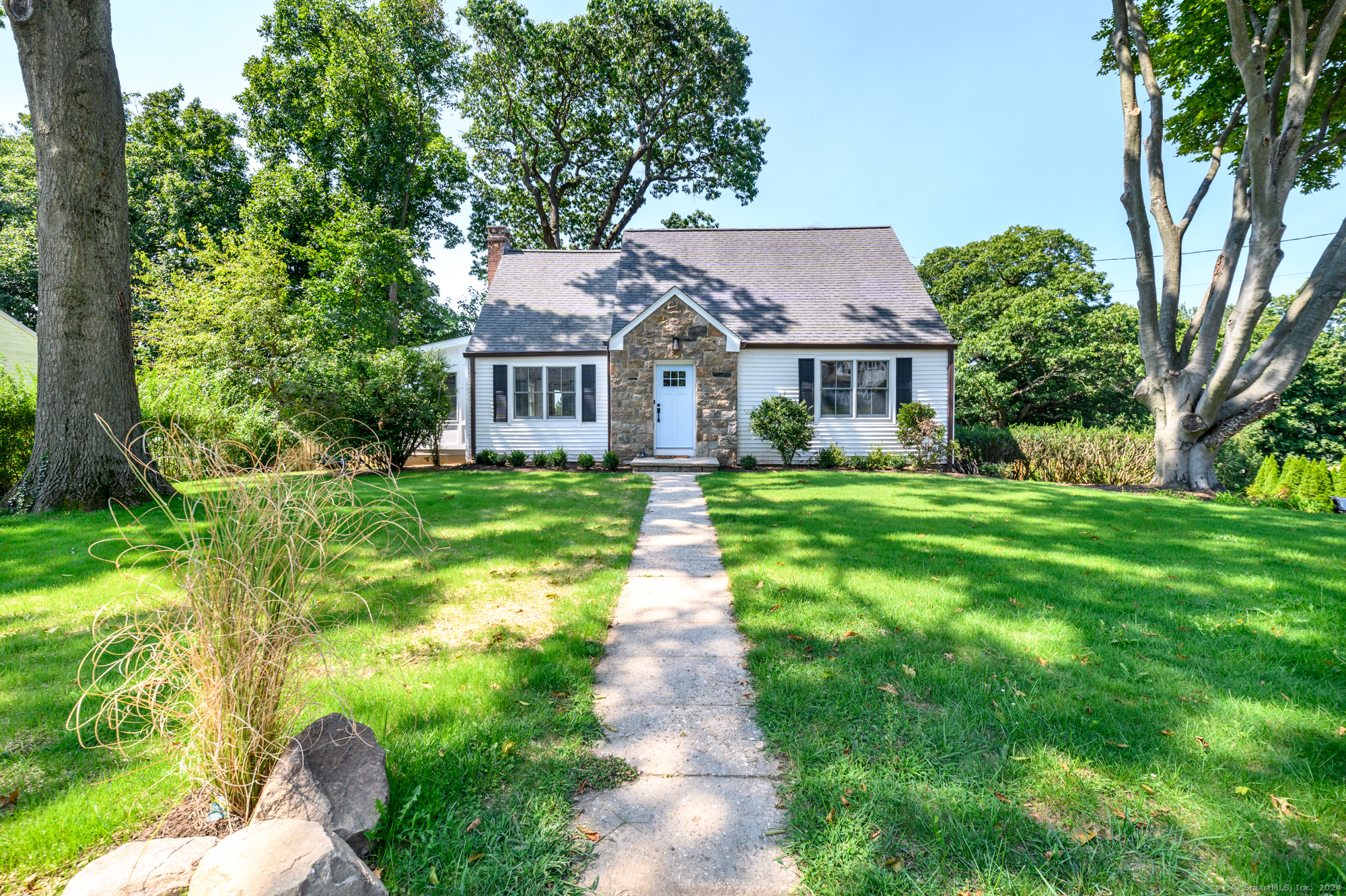 a front view of a house with yard and green space
