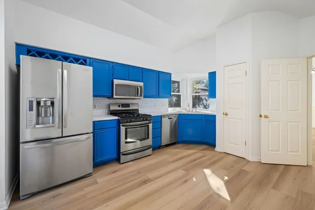 a kitchen with stainless steel appliances a refrigerator and a stove top oven