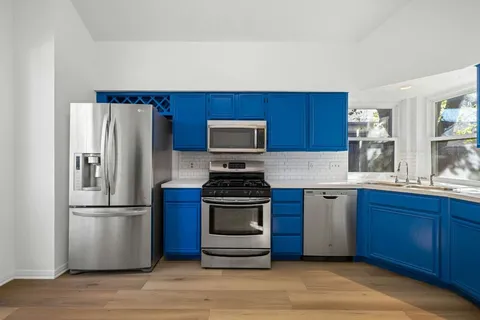 a kitchen with granite countertop stainless steel appliances and wooden cabinets