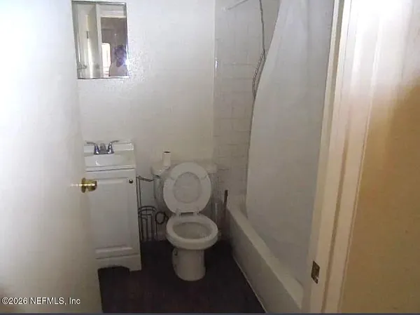 a bathroom with a toilet and a mirror