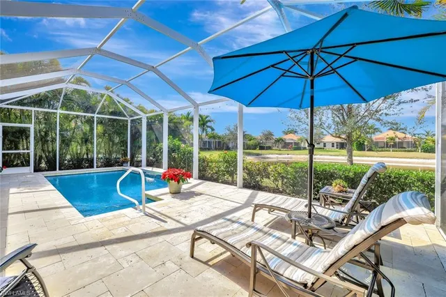 a view of a patio with a table and chairs under an umbrella