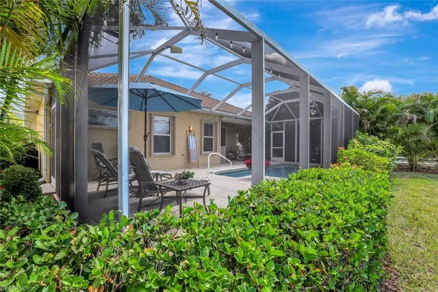 a view of a chair and table in backyard of the house