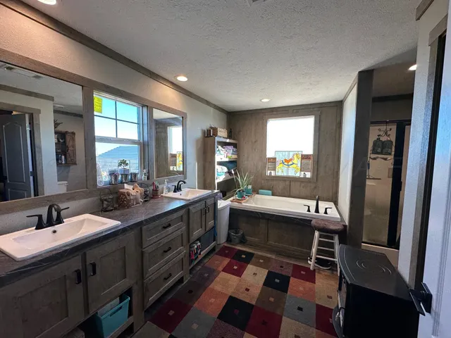 a large white kitchen with a sink and a large window