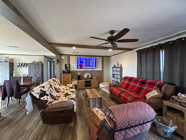 a living room with furniture a ceiling fan and a rug