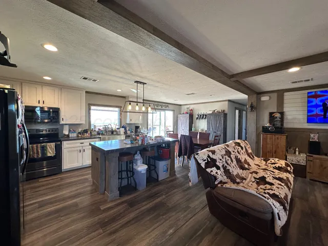 a living room with lots of furniture and kitchen view