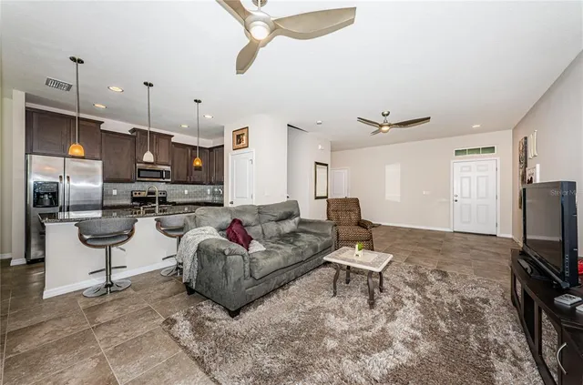 a living room with furniture and kitchen view