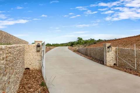 a view of a dry yard with wooden fence