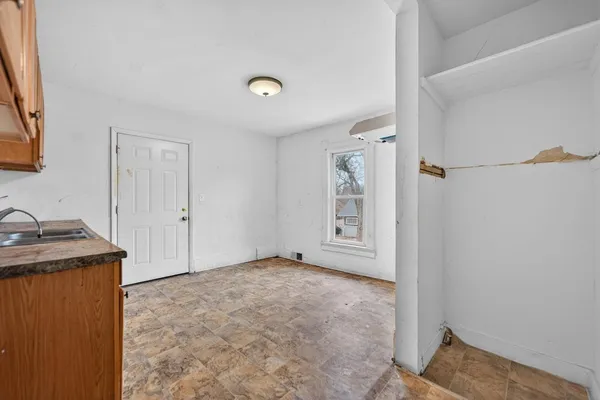 an empty room with wooden floor chandelier fan and windows