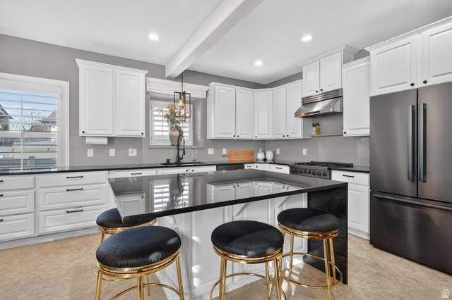 14738 Tangle Hill Road Herriman, UT 84096 - Photo 18 of 66 Spacious kitchen featuring white cabinetry, dark countertops, a large center island with seating, stainless steel range hood, and a black French door refrigerator