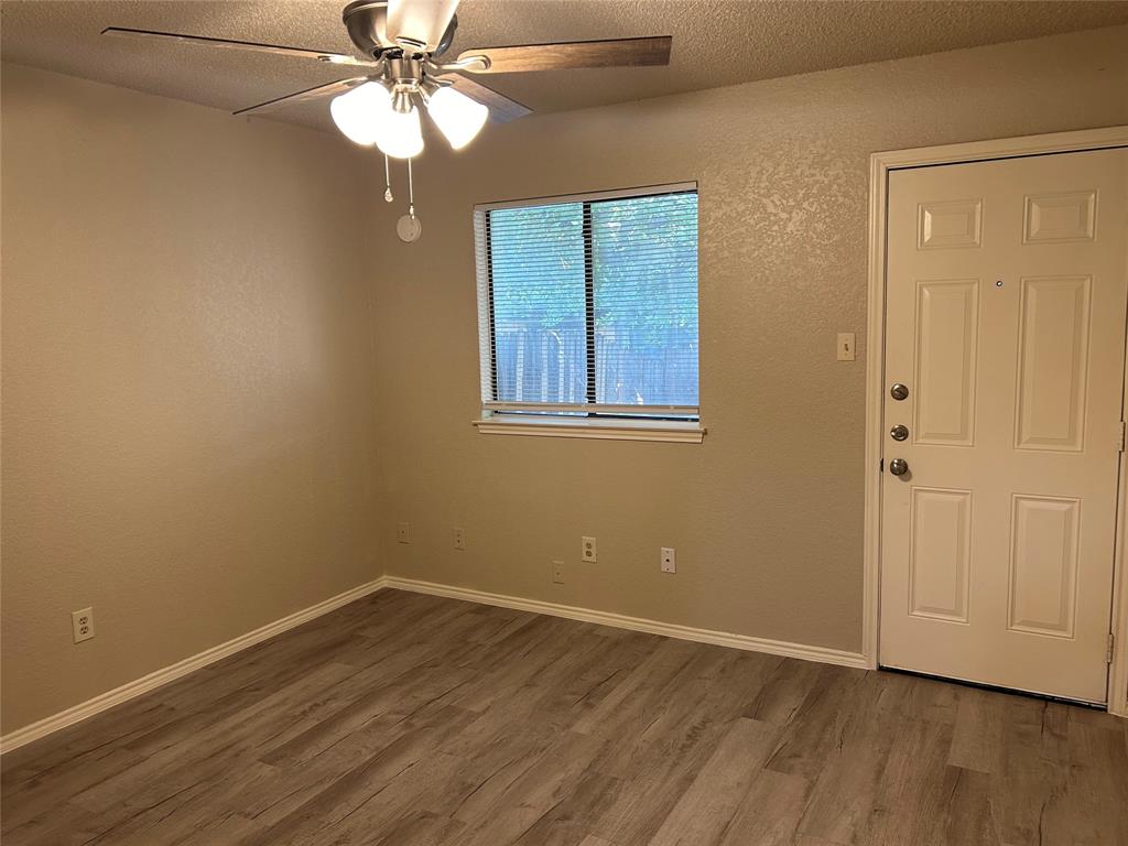 4508 Compass Court Fort Worth, TX 76135 - Photo 15 of 21 a view of an empty room with wooden floor and a window
