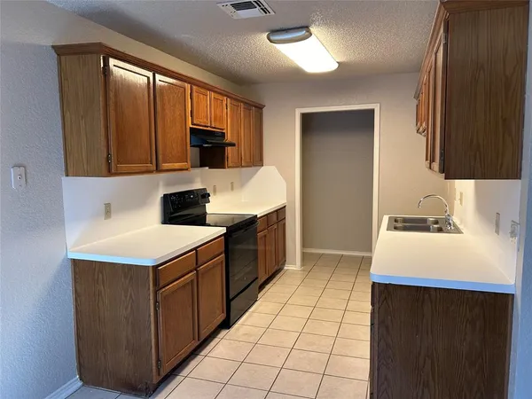 a kitchen with a sink a stove top oven and cabinets