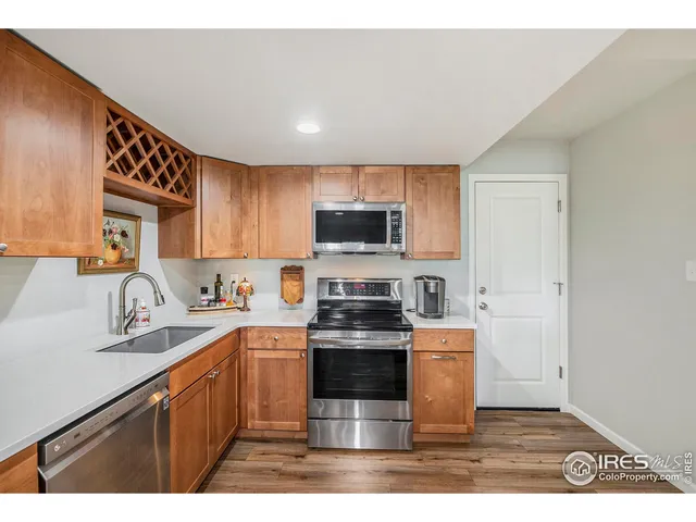 a kitchen with stainless steel appliances granite countertop a stove a sink dishwasher and a microwave oven with wooden cabinets