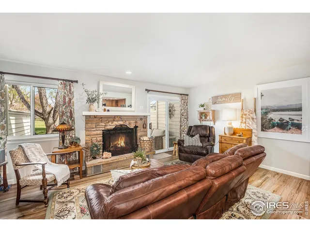 a living room with furniture large window and a fireplace