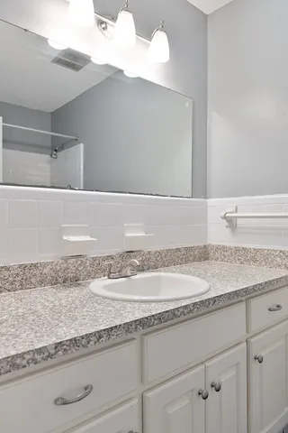 a bathroom with a granite countertop toilet and a sink