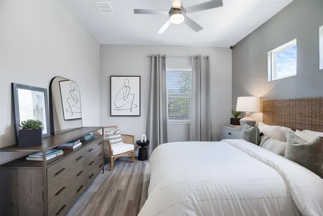 a bedroom with a large bed and wooden floor