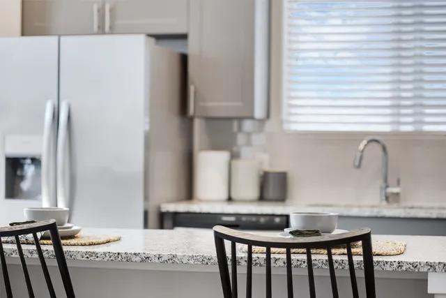 a kitchen with granite countertop a sink and a refrigerator