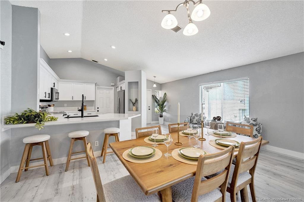 4365 Pine Ridge Court Weston, FL 33331 - Photo 12 of 63 a dining room with wooden floor a chandelier a wooden table and chairs