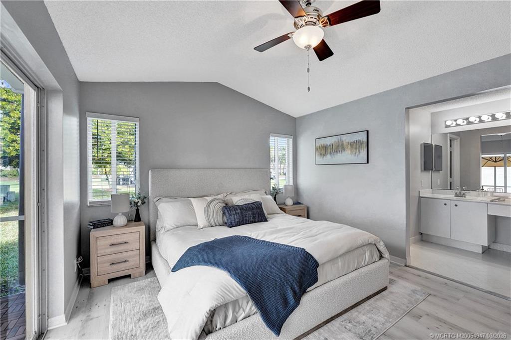 4365 Pine Ridge Court Weston, FL 33331 - Photo 28 of 63 a bedroom with a large bed and a chandelier