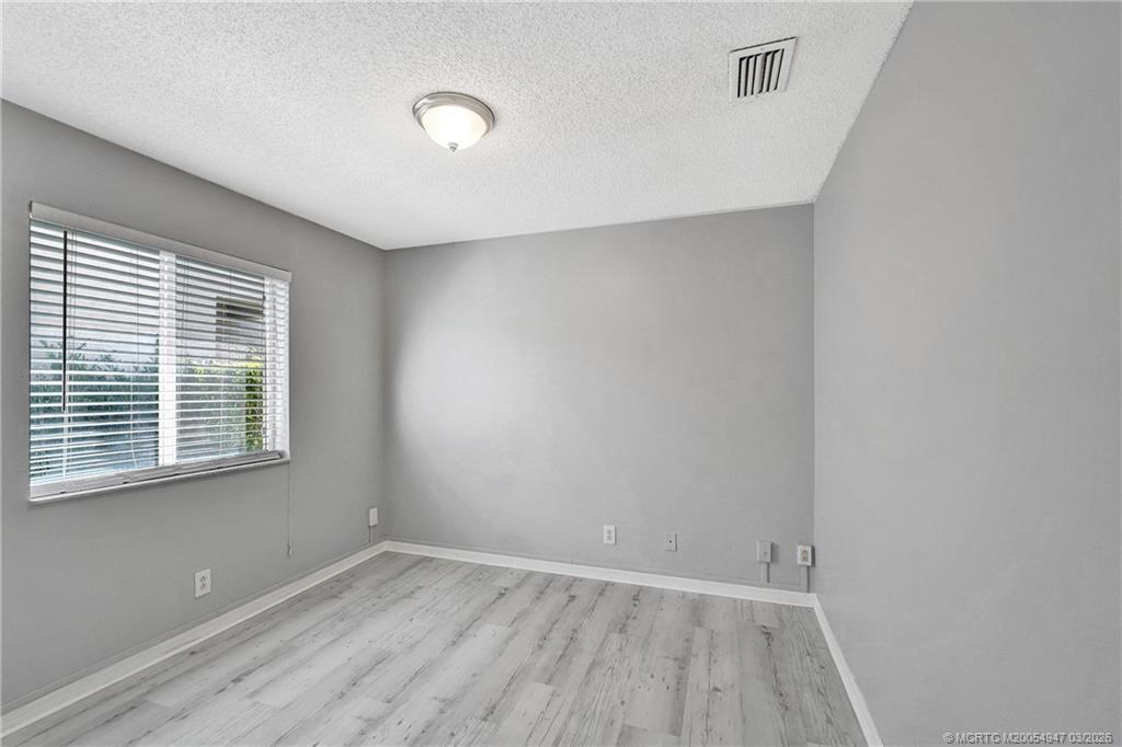 4365 Pine Ridge Court Weston, FL 33331 - Photo 32 of 63 a view of an empty room with wooden floor and a window