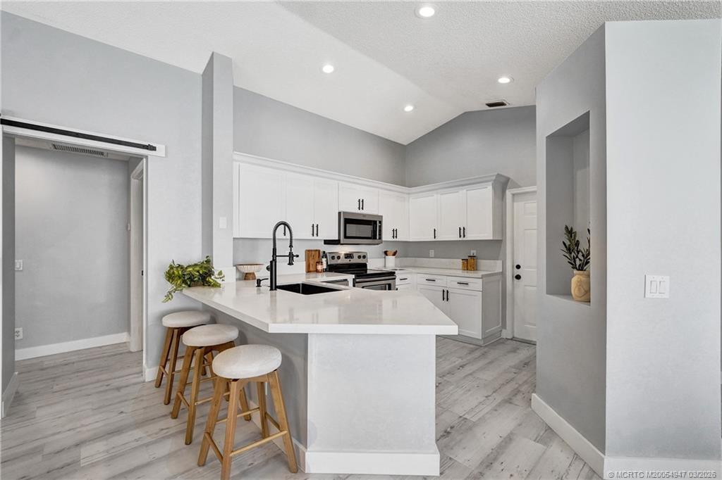 4365 Pine Ridge Court Weston, FL 33331 - Photo 6 of 63 a kitchen with stainless steel appliances kitchen island granite countertop a refrigerator and a stove top oven