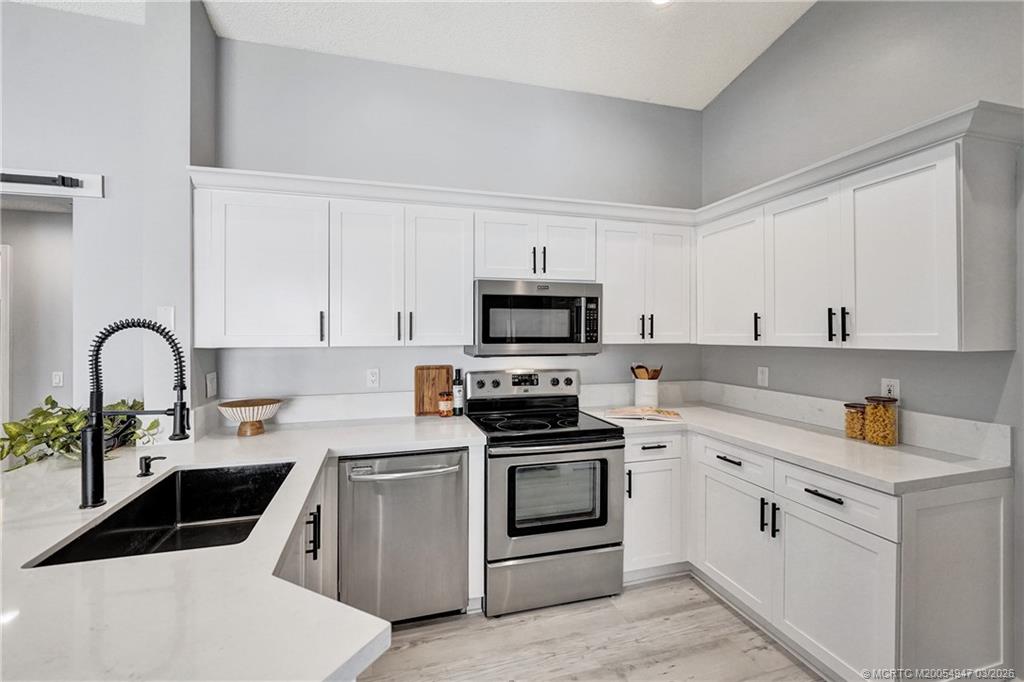 4365 Pine Ridge Court Weston, FL 33331 - Photo 7 of 63 a kitchen with white cabinets stainless steel appliances and sink