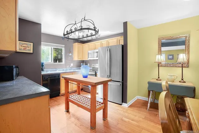 a kitchen with stainless steel appliances granite countertop a refrigerator a sink a stove and white cabinets