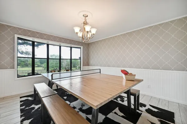 a view of a dining room with furniture a chandelier and wooden floor