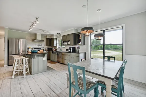 a kitchen with a table chairs stainless steel appliances and cabinets