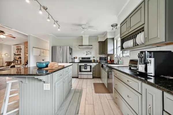 a kitchen with stainless steel appliances granite countertop a sink and cabinets