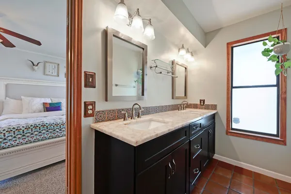 a bathroom with a granite countertop sink and a mirror