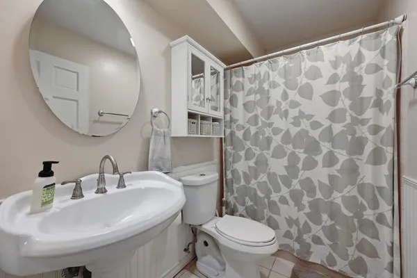 a bathroom with a sink a toilet and a mirror