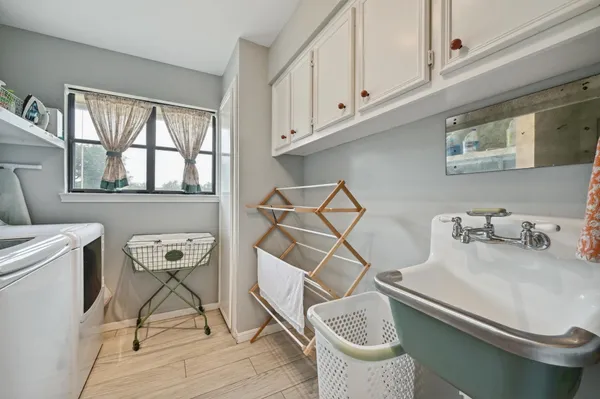 a bathroom with a sink a chair and potted plant on the table
