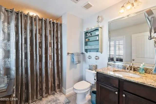 a bathroom with a granite countertop toilet sink and mirror
