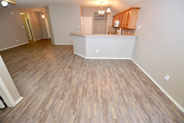 a view of empty room with wooden floor and window