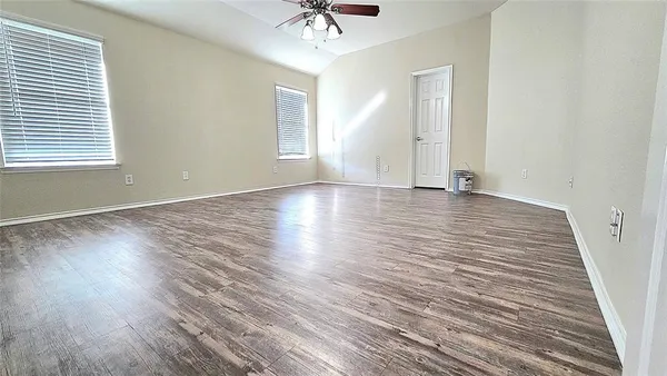 a view of an empty room with wooden floor