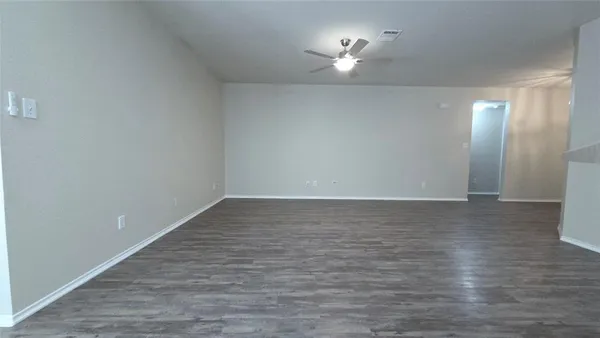 wooden floor in an empty room with a kitchen