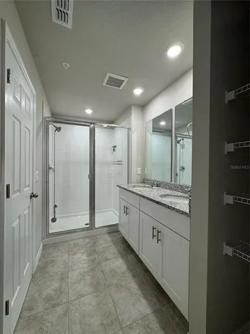a bathroom with a granite countertop sink mirror and shower