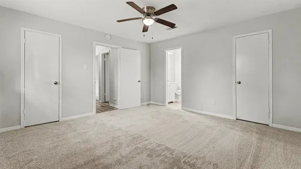 a view of an empty room and a ceiling fan