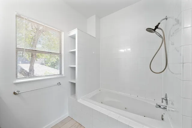a bathroom with a bath tub with a shower
