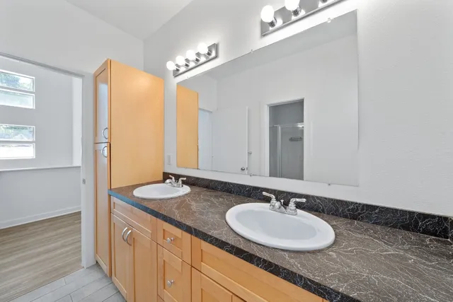 a bathroom with a granite countertop sink and a mirror