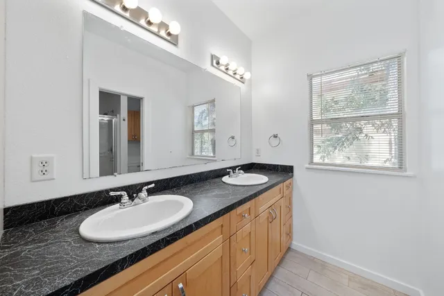 a bathroom with a granite countertop sink and a mirror