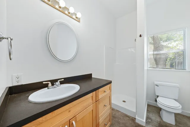 a bathroom with a sink a toilet and a mirror