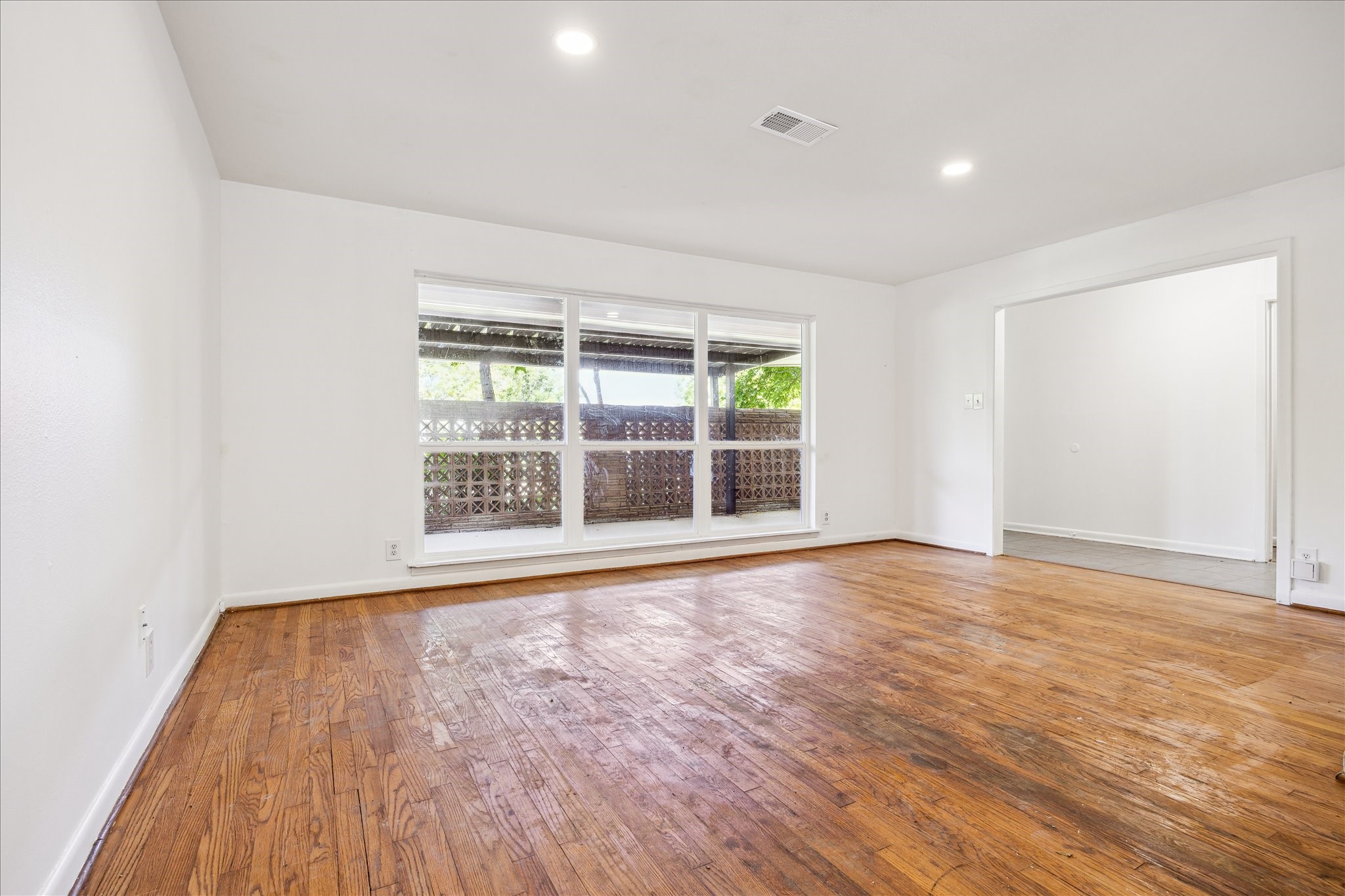 5419 Beechnut Street Houston, TX 77096 - Photo 5 of 28 Flooded with natural light, this inviting front living room is ideal for relaxing or entertaining, featuring a large picture window and timeless wood flooring.