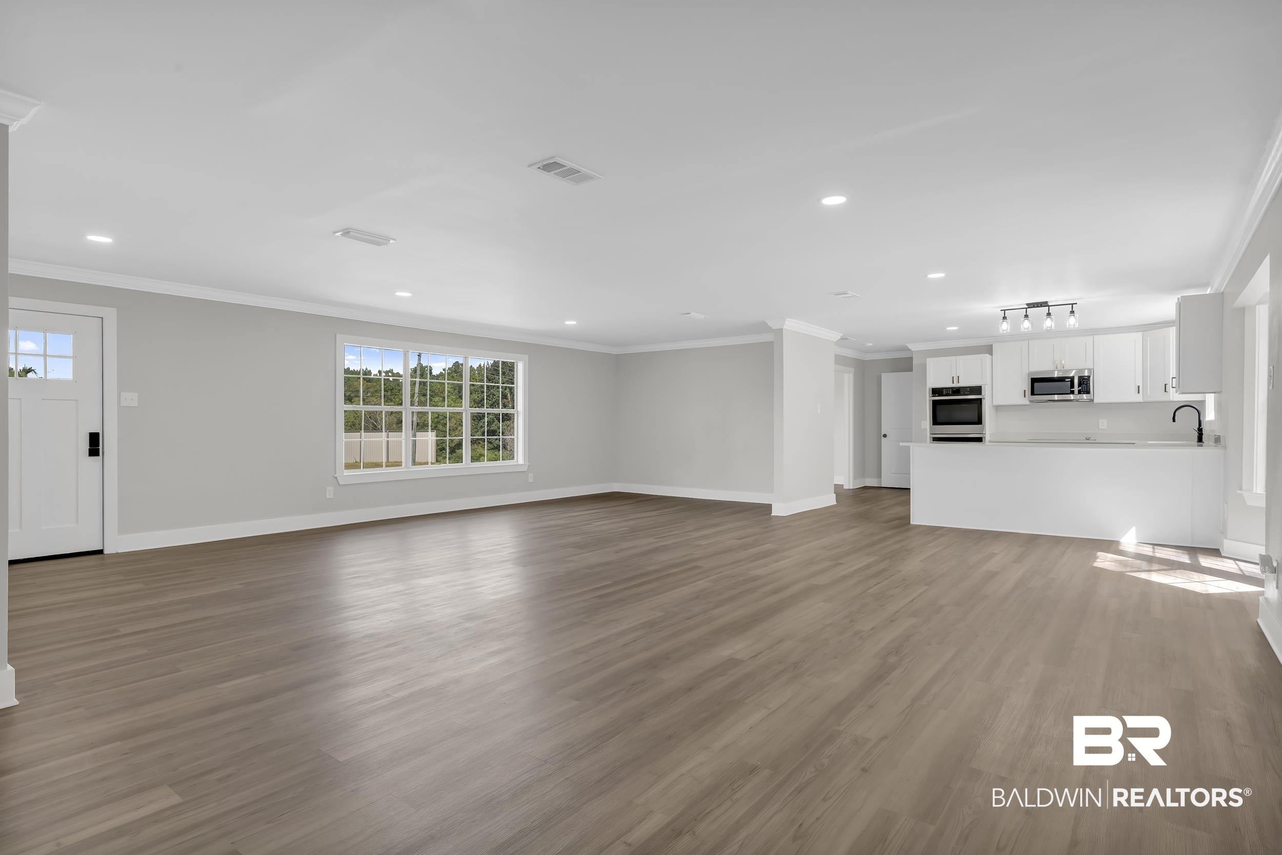 8351 Theodore Dawes Road Theodore, AL 36582 - Photo 10 of 46 Unfurnished living room with ornamental molding, light wood-type flooring, and recessed lighting
