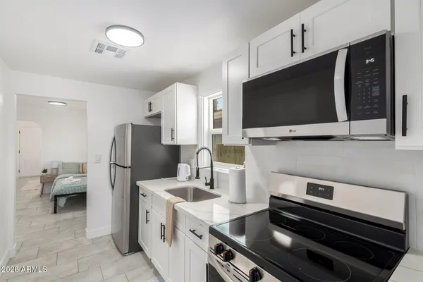 a kitchen with a refrigerator and a stove top oven