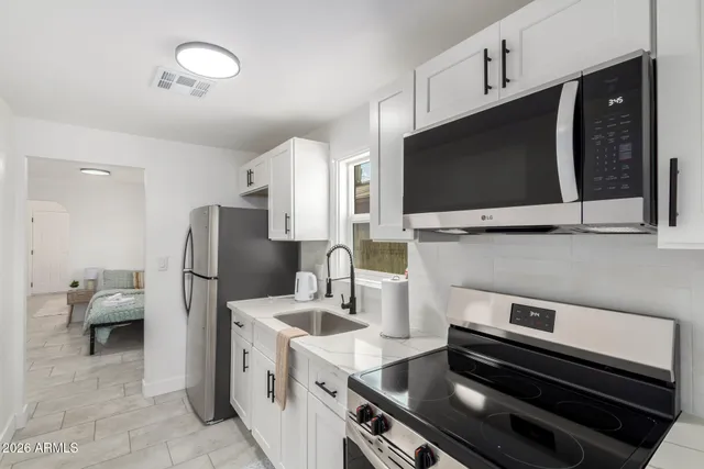 a kitchen with a refrigerator and a stove top oven