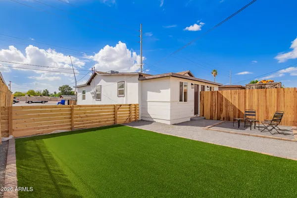 a view of a backyard with table and chairs and a barbeque